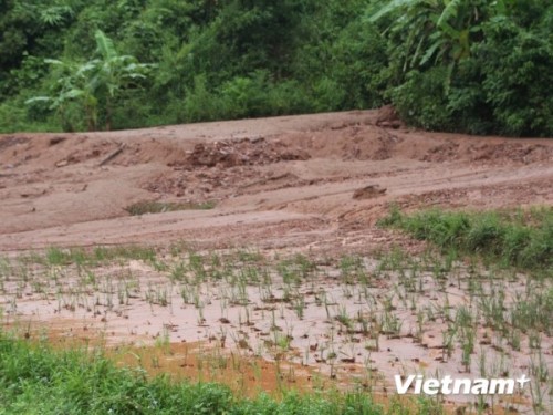 Đất, đá từ bãi quặng Nà Rụa vùi lấp đất canh tác của người dân (Ảnh: Hùng Võ/VietnamPlus)