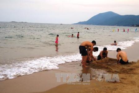 Nhiều du khách trong và ngoài tỉnh đến tắm biển Thiên Cầm trong chiều 30/4 khi có kết luận quan trắc môi trường nước biển nằm trong giới hạn cho phép (Ảnh: Phan Quân - TTXVN) 